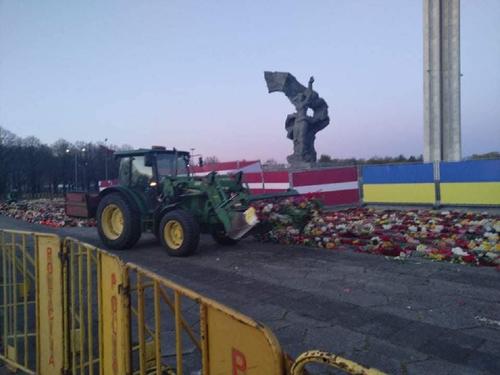 Власти Латвии бульдозером сгребли принесённые людьми цветы у памятника Освободителям Риги