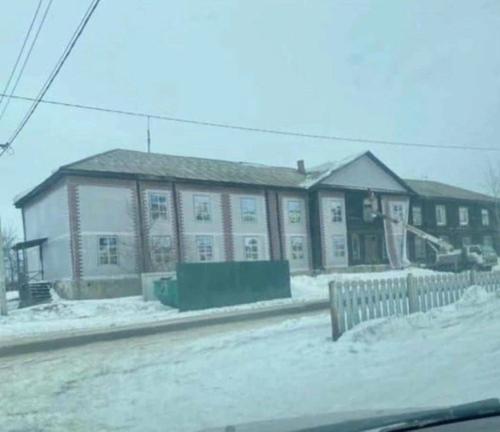 В Кемеровской области перед приездом губернатора Цивилёва деревянный барак завесили баннером с фотографией нового дома