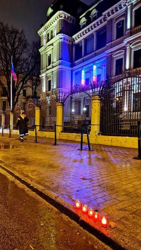 Латвийцы несут свечи к Посольству РФ в Риге