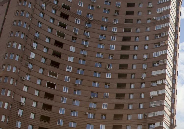 Девушка висит на фасаде многоэтажки в Новой Москве на глазах у прохожих