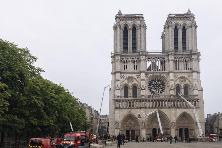 Пожарные осматривают левую башню собора Парижской Богоматери после пожара