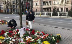 Жители Латвии продолжают нести к Посольству России в Риге цветы, свечи