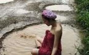 Плохие дороги вынудили тайских женщин купаться в дорожных ямах (ФОТО)